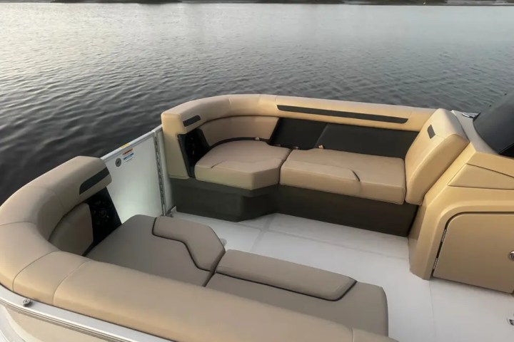 Beige cushioned seating on a boat deck overlooking a calm body of water.
