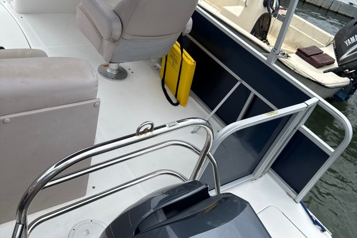 View of a boat's interior with seating and Yamaha 150 engine at a dock.